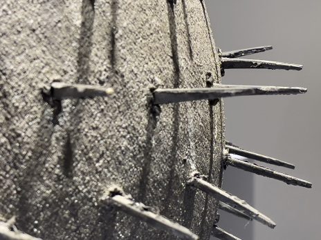 A spherical sculpture with many spikes protruding out of it.
