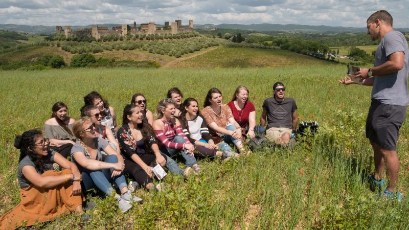 person talking to students on italian hillside
