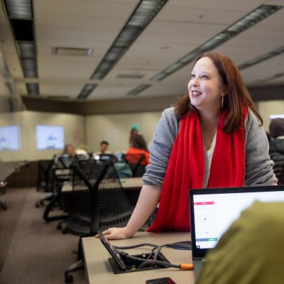 Becky Smiles surrounded by students in a classroom