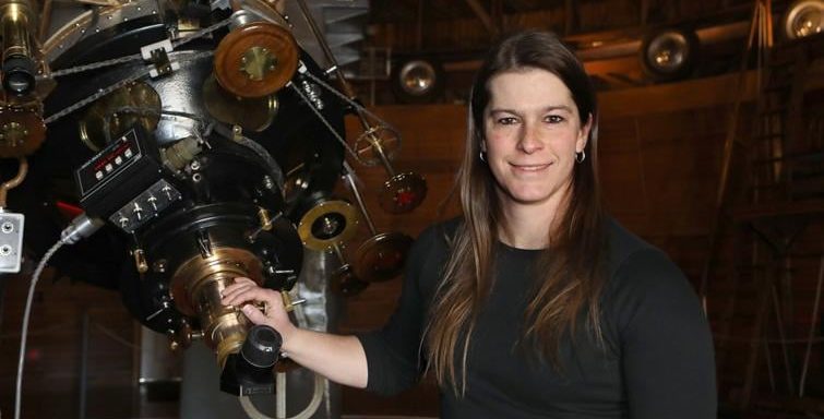 Sam Hemmelgarn stands beside the Clarke Telescope.