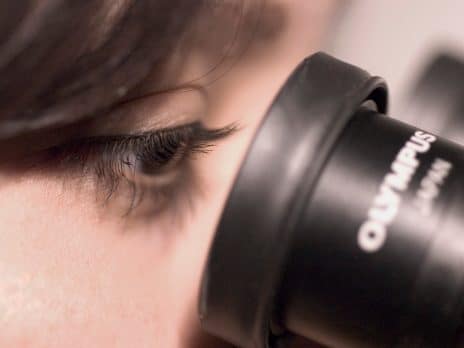 student looking through a microscope