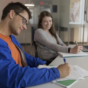 Students taking notes at a desk