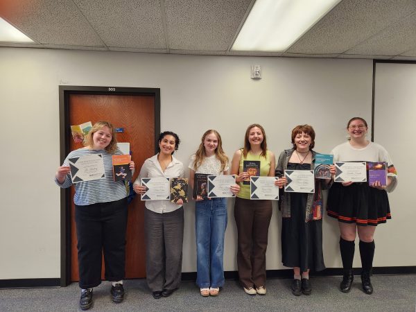 6 people smile holding books and certificates