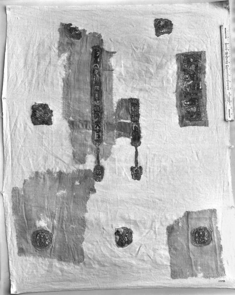 The image shows a fragment of an ancient tunic in black and way. 