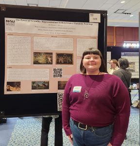 A woman in a maroon sweater stands in front of a pink and white research poster.