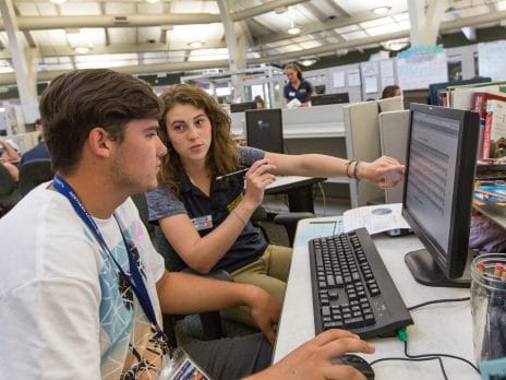 student choosing courses online with assistance from advisor 