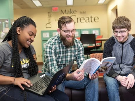 Three NAU students reading their notes