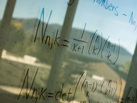 math problem written on a whiteboard, side view