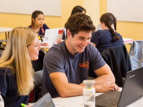 a math tutor helps a smiling student on a computer