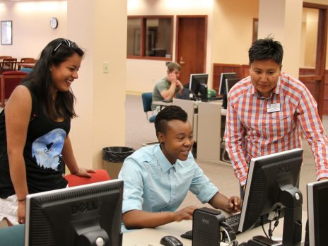 Student working on computer with teacher.