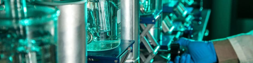 A research lab depicting controlled experiments with a hand in the picture adjusting the equipment