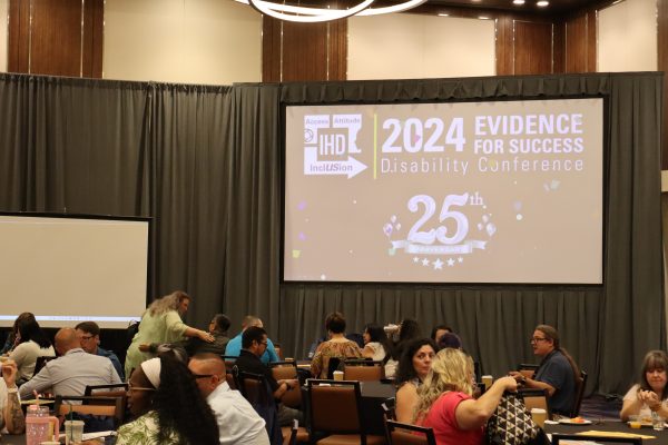 photo of stage at IHD conference showing the screen and audience members