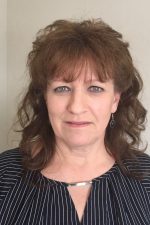 A photo of Gaye Champine is shown. Gaye is a white woman with brown hair, she has blue eyes and is wearing a dark blouse.