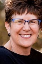 A photograph of Heidi Lervik is shown. Heidi is a white woman with short brown hair, blue glasses, brown eyes. She is smiling at the camera.