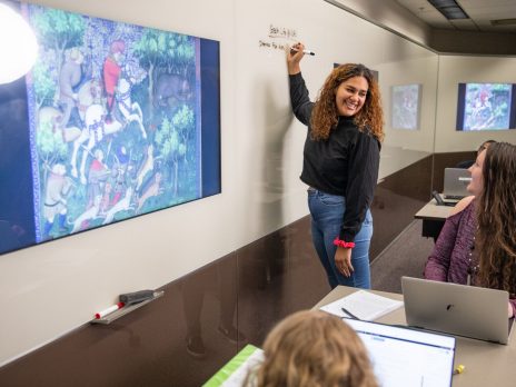 Female student writing at a whiteboard