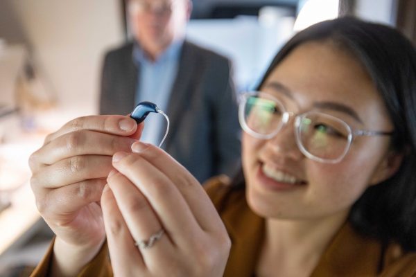 A student holding up a gadget.