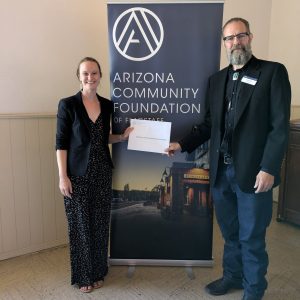 Meredith Brown and Andrew See hold a certificate about their Arizona Community Foundation award.