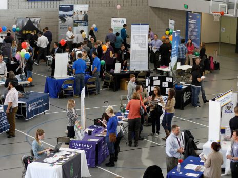 nau students in the mac gym of the hlc. booths and flyers are set up.
