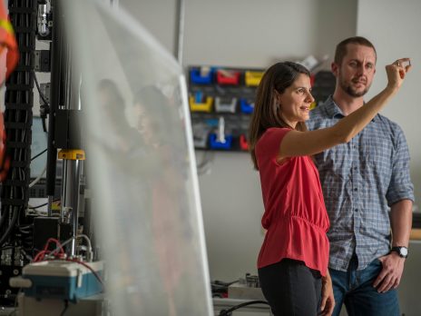 photo of man and woman studying an object in a work shop
