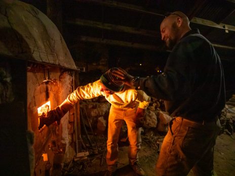 Student and instructor heating ceramics in furnace