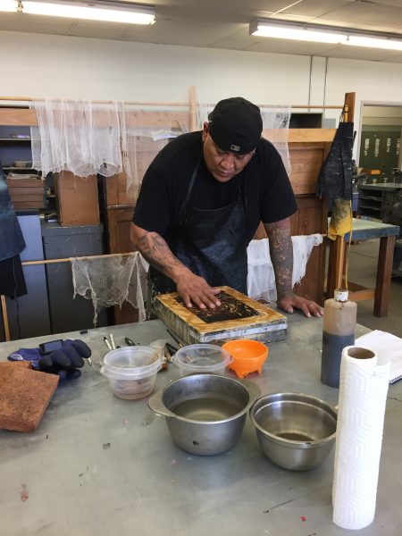 A student processes a lithograph stone in preparation for printing