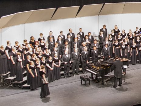 Choir students standing together on stage ready to perform.
