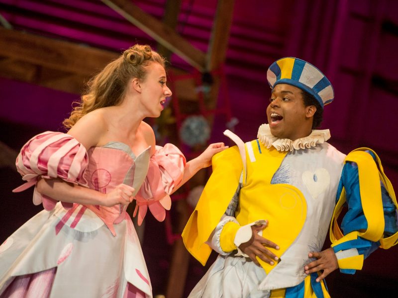 a male and female student performing in vibrant costumes