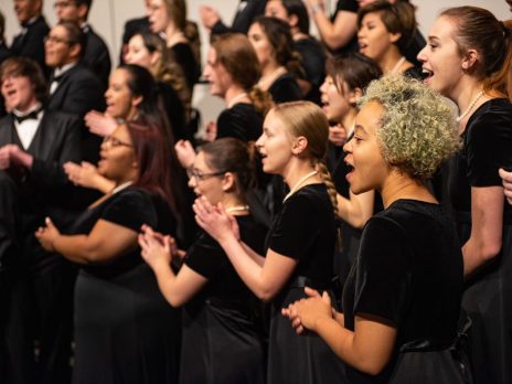 Choir students dressed up and singing together.
