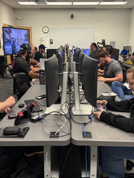 Members of ITS gathered around computer monitors and video game consoles.