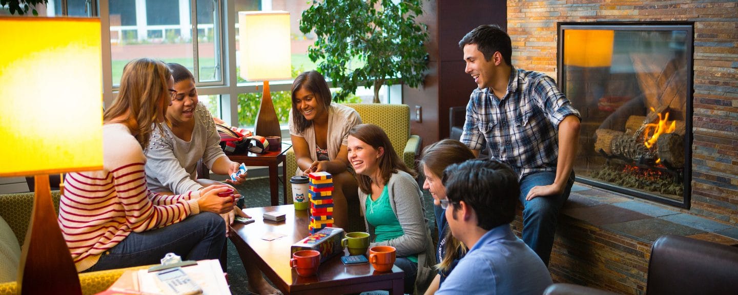 campus residents play jenga and other board games and are laughing together