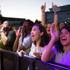 Students celebrate at a concert in purple light