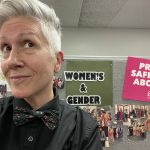 A portrait photo of Carla Wilson with a Women's and Gender studies banner in the background.