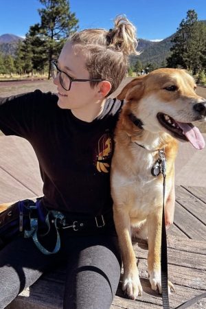 PIcture of Faith with dog Artemis and Peaks in the background