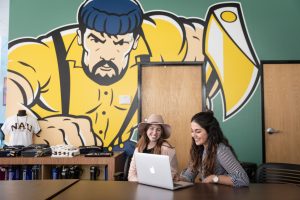 Two students work at the N A U Bookstore.