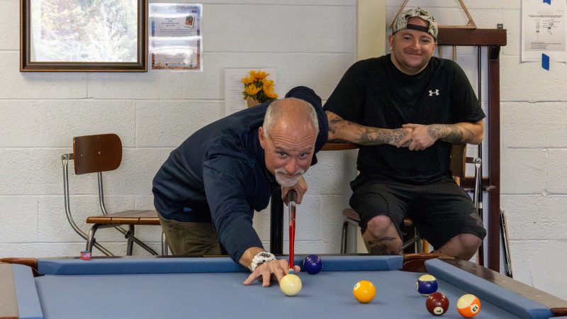 Student and staff member playing pool in the Veteran Success Center