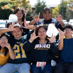 NAU family members forming a "L" and a "J" with their hands.