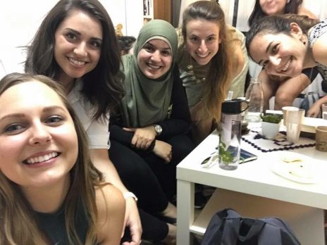 students around a coffee table taking selfie