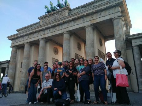 teachers pose in front of monument in German