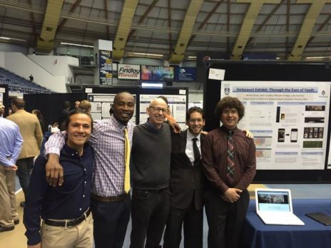 students pose with professor at undergraduate research symposium