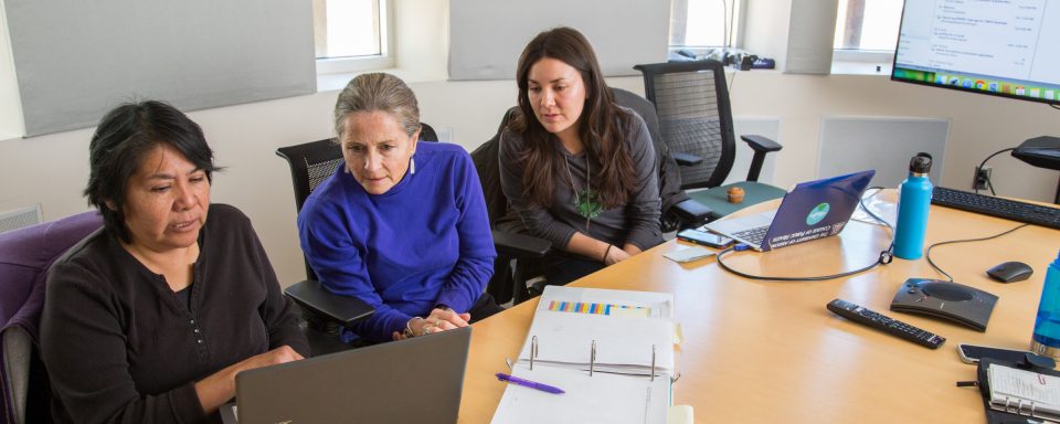 CHER staff sitting around a table working in a conference room.