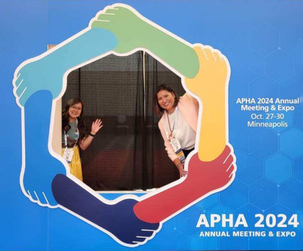 Cropped photo of Carmenlita and Jennifer posing at an APHA 2024 decor sign