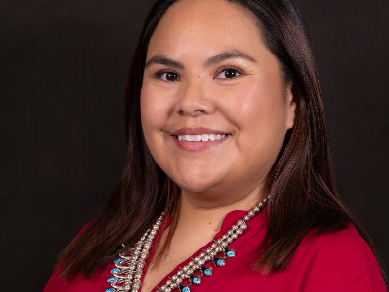 Asia-Soleil Yazzie wearing a red top and a silver and turquoise necklace