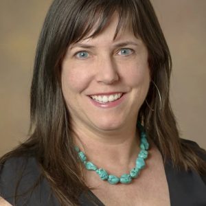 photo of julie armin wearing a black top and turquoise necklace