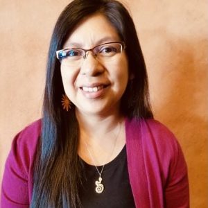 photo of Jessica Onsae wearing a black top with a pink cardigan and a silver necklace