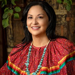 Maria Dadgar with a red multi-colored traditional top and turquoise necklace