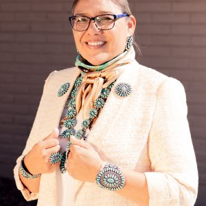 Tanya Riggs wearing a peach suit and scarf, flourished with turquoise and silver jewelry