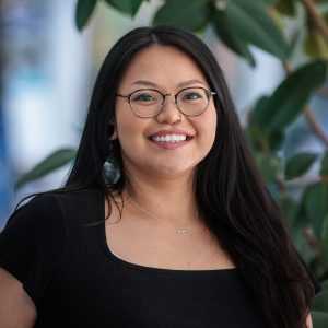 Photo of DeeDee James wearing glasses, a black top and abalone earrings