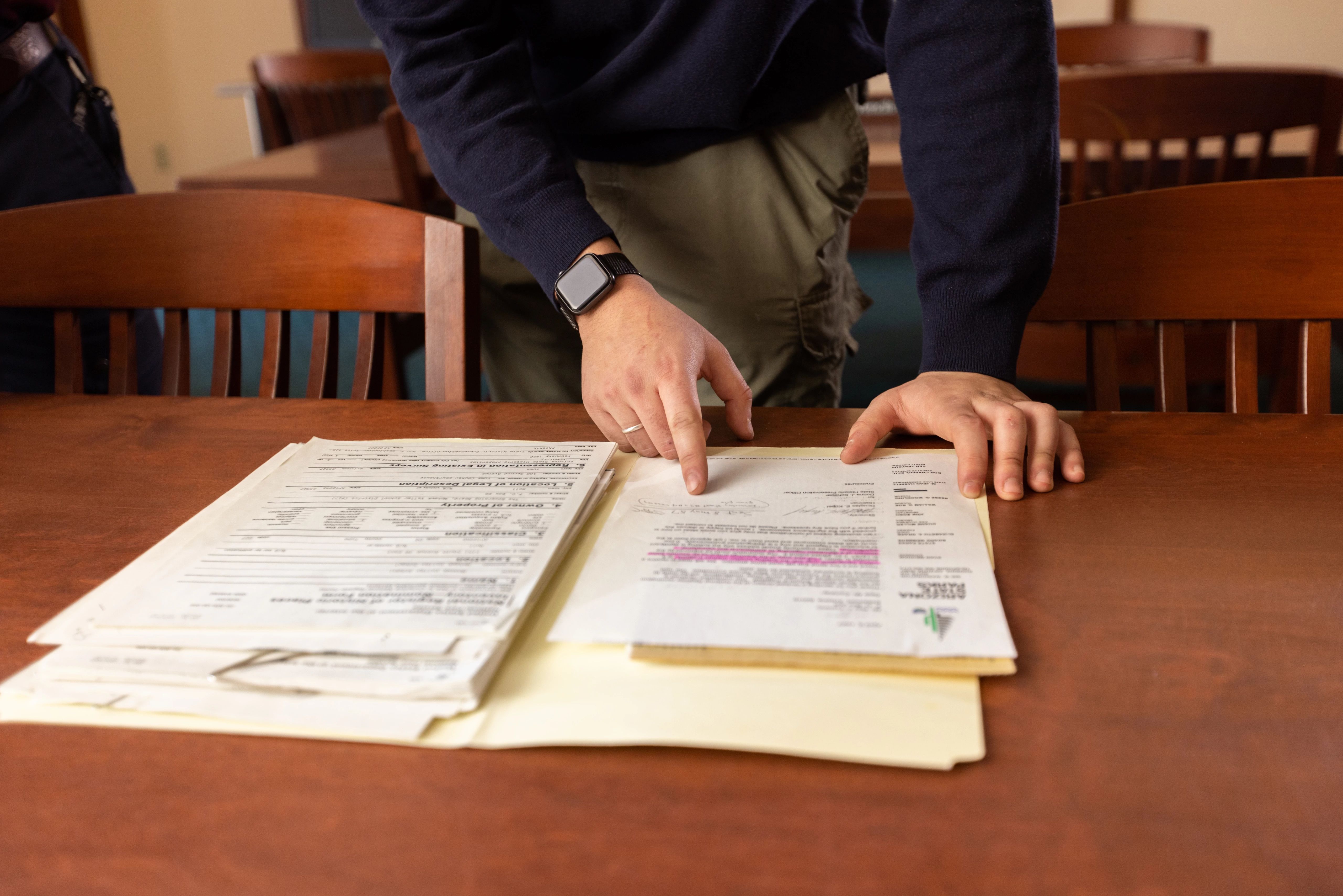 A man going through a folder of old records in special collections.