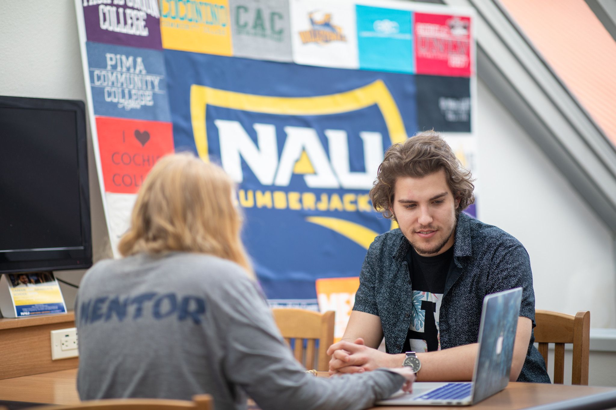 A transfer student talking at a table with a NAU mentor.