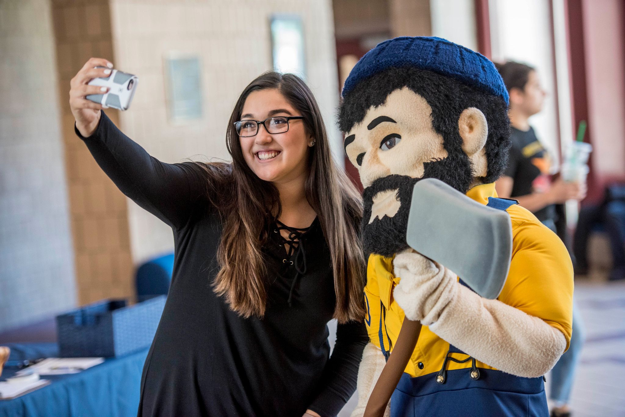 NAU student takes a photo with Louie the Lumberjack.